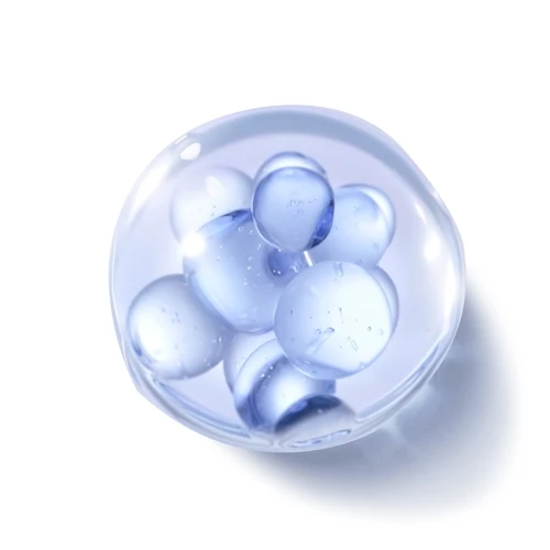 Clear glass marble containing several blue bubbles inside on a white background.