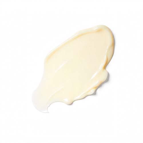 A dollop of light beige cream swiped on a white background.